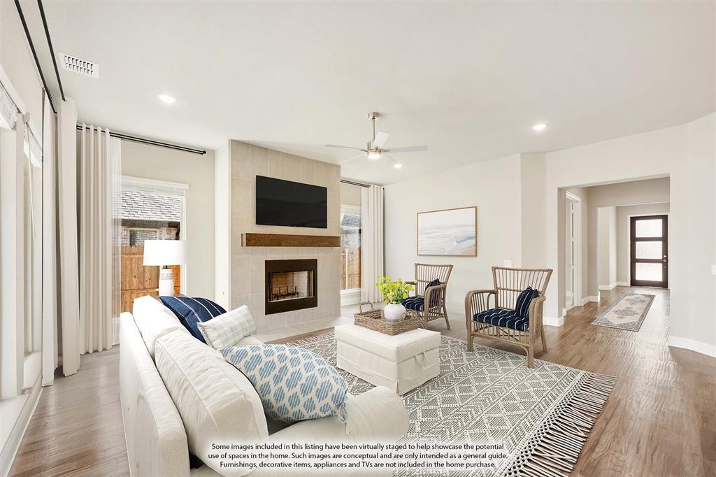 1004 Stonehaven Drive Justin, TX 76247 - Photo 12 of 35 a living room with furniture a fireplace and a flat screen tv
