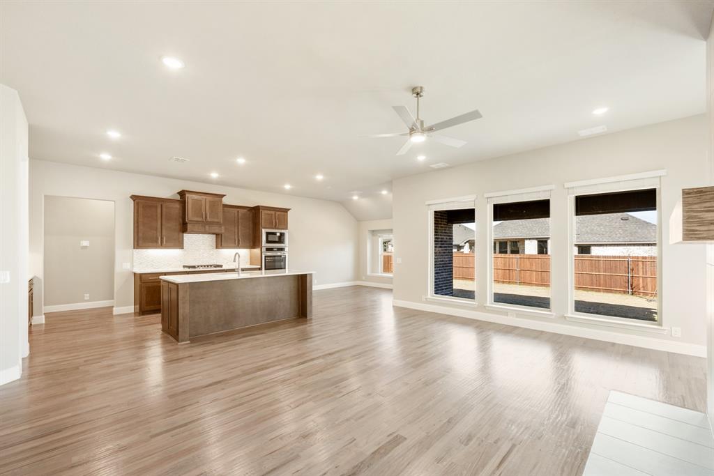 1004 Stonehaven Drive Justin, TX 76247 - Photo 13 of 35 a large kitchen with stainless steel appliances kitchen island a large counter top and a wooden floor
