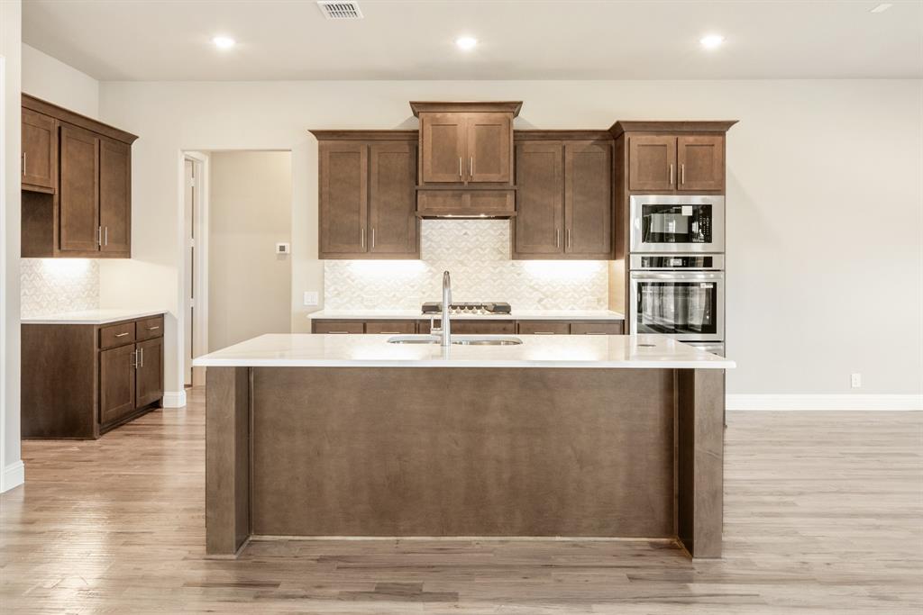 1004 Stonehaven Drive Justin, TX 76247 - Photo 14 of 35 a view of kitchen with stainless steel appliances granite countertop cabinets and wooden floor
