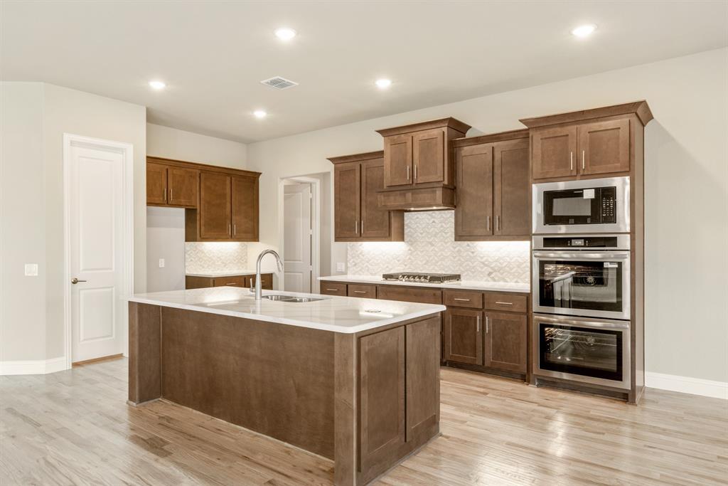 1004 Stonehaven Drive Justin, TX 76247 - Photo 15 of 35 a large kitchen with stainless steel appliances granite countertop a stove and a refrigerator