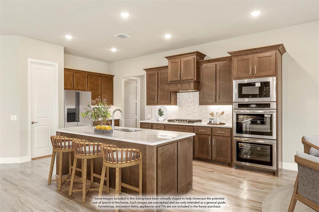 1004 Stonehaven Drive Justin, TX 76247 - Photo 16 of 35 a large kitchen with stainless steel appliances granite countertop a stove and a refrigerator