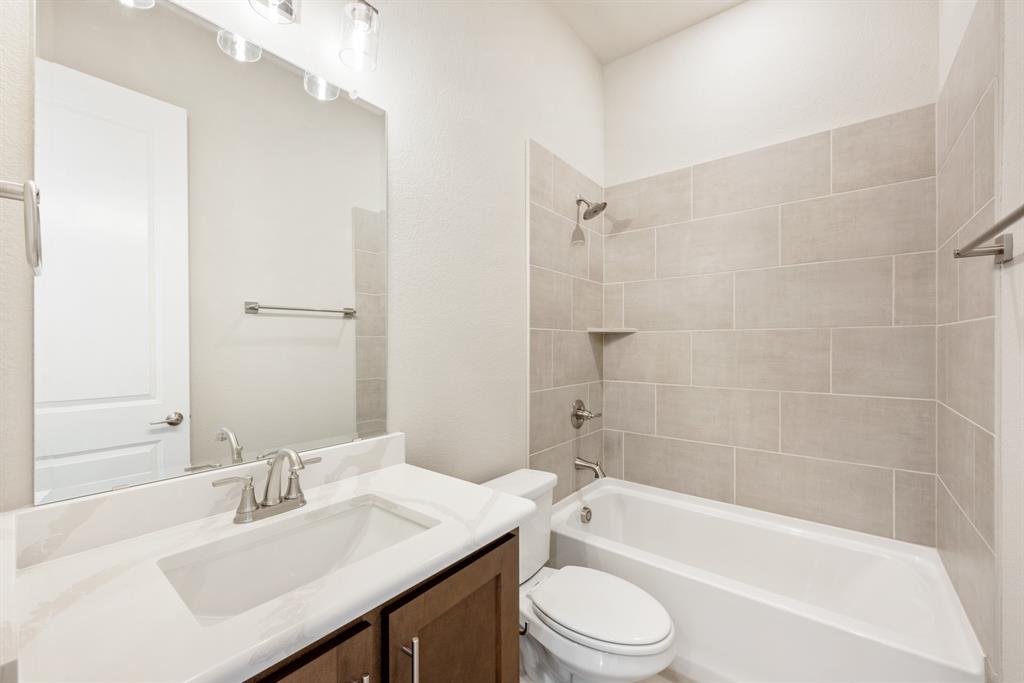 1004 Stonehaven Drive Justin, TX 76247 - Photo 29 of 35 a bathroom with a bathtub shower sink vanity mirror and toilet