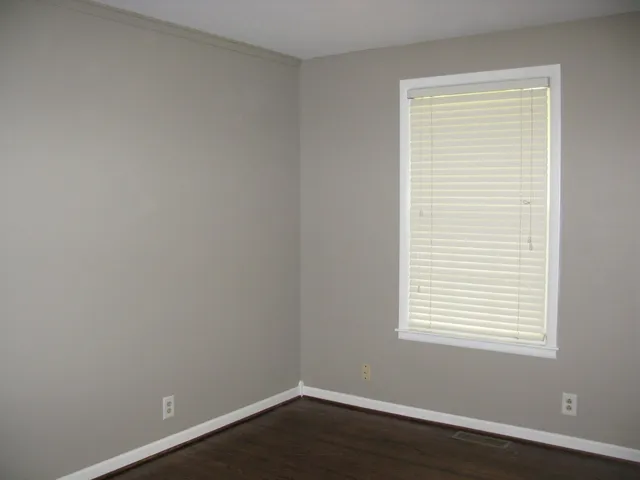 a view of a small space with wooden floor and a window