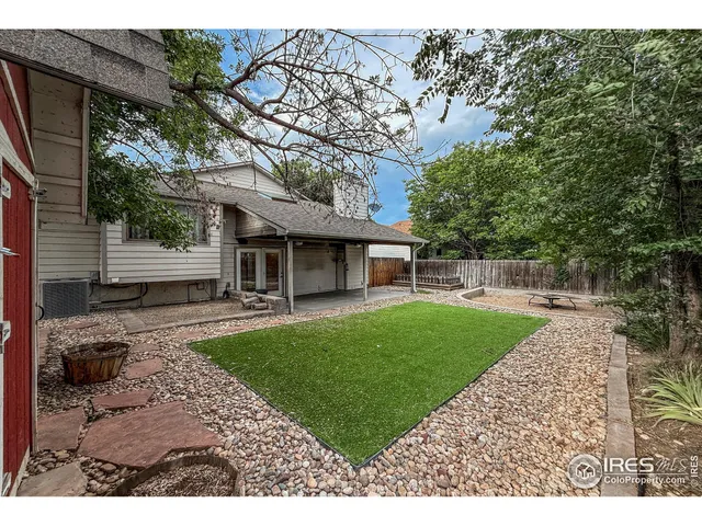 a view of a house with backyard and a tree