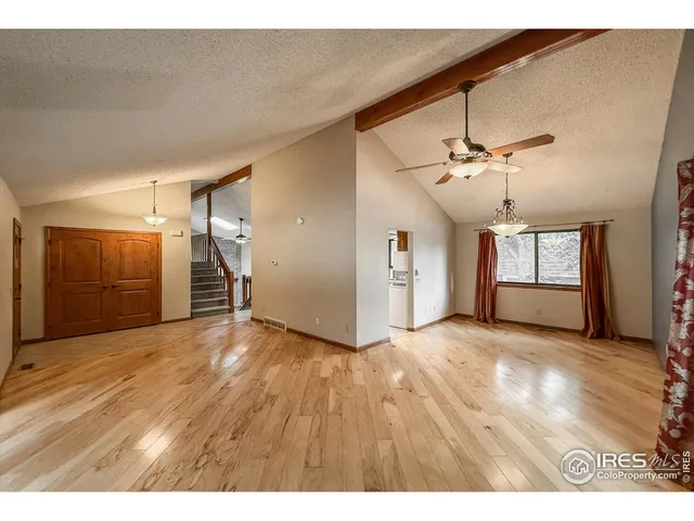 a view of empty room with wooden floor and window