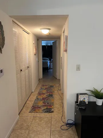 a view of a hallway and a livingroom with furniture