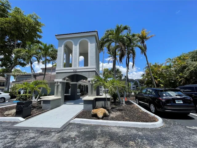 a front view of a house with fountain plants