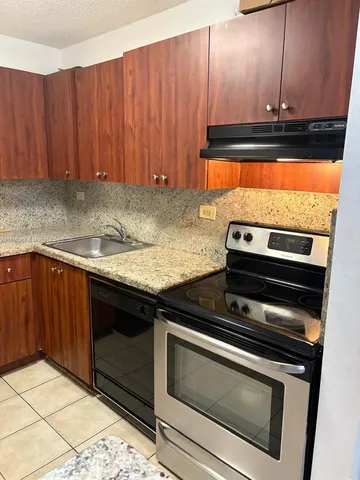 a kitchen with wooden cabinets and a stove top oven