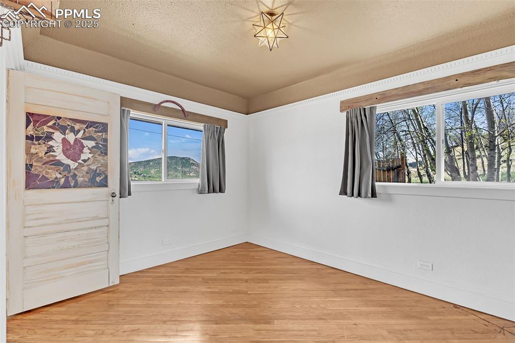 123 7th Street Victor, CO 80860 - Photo 12 of 50 Main bedroom off the entry hallway and living room featuring wood floors