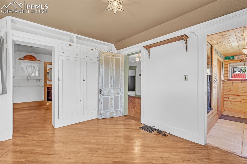 123 7th Street Victor, CO 80860 - Photo 15 of 50 Main bedroom featuring light wood-type flooring going into the closet and attached 3/4 bath, baseboards and access to living room and hallway leading to front door.