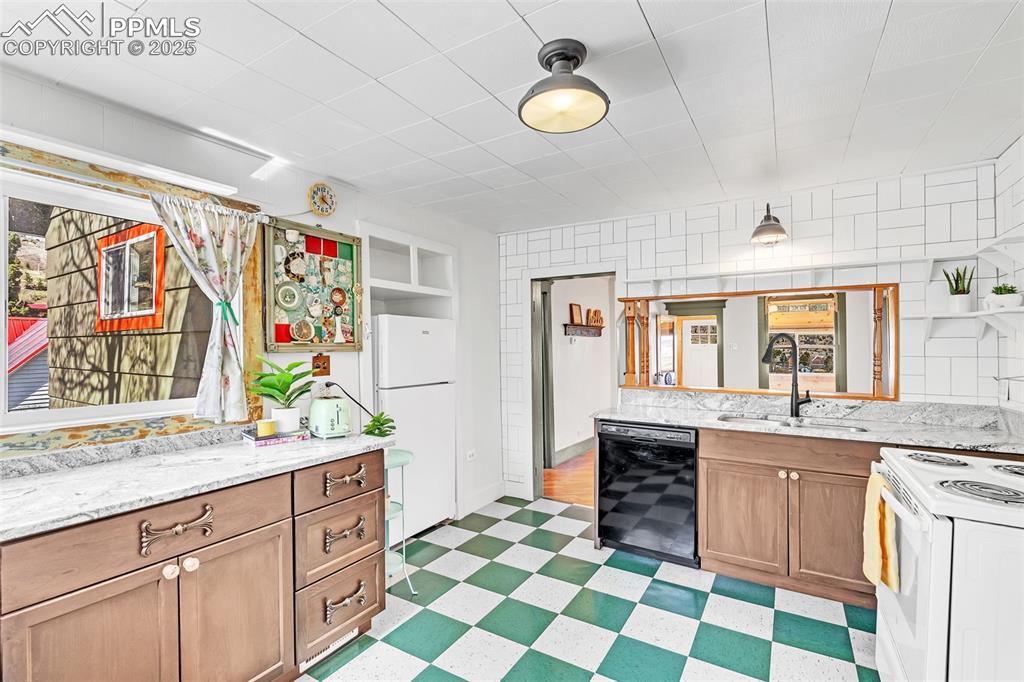 123 7th Street Victor, CO 80860 - Photo 29 of 50 Kitchen featuring white appliances, a sink, light flooring, and light stone countertops