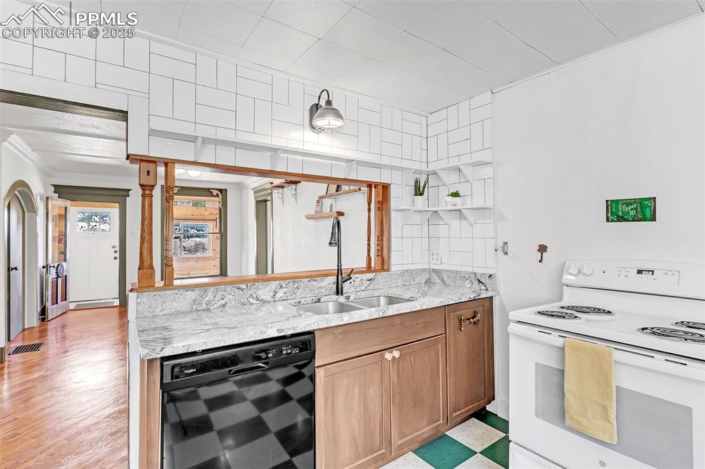123 7th Street Victor, CO 80860 - Photo 34 of 50 Kitchen with electric stove, a sink, open shelves, crown molding, and light stone counters