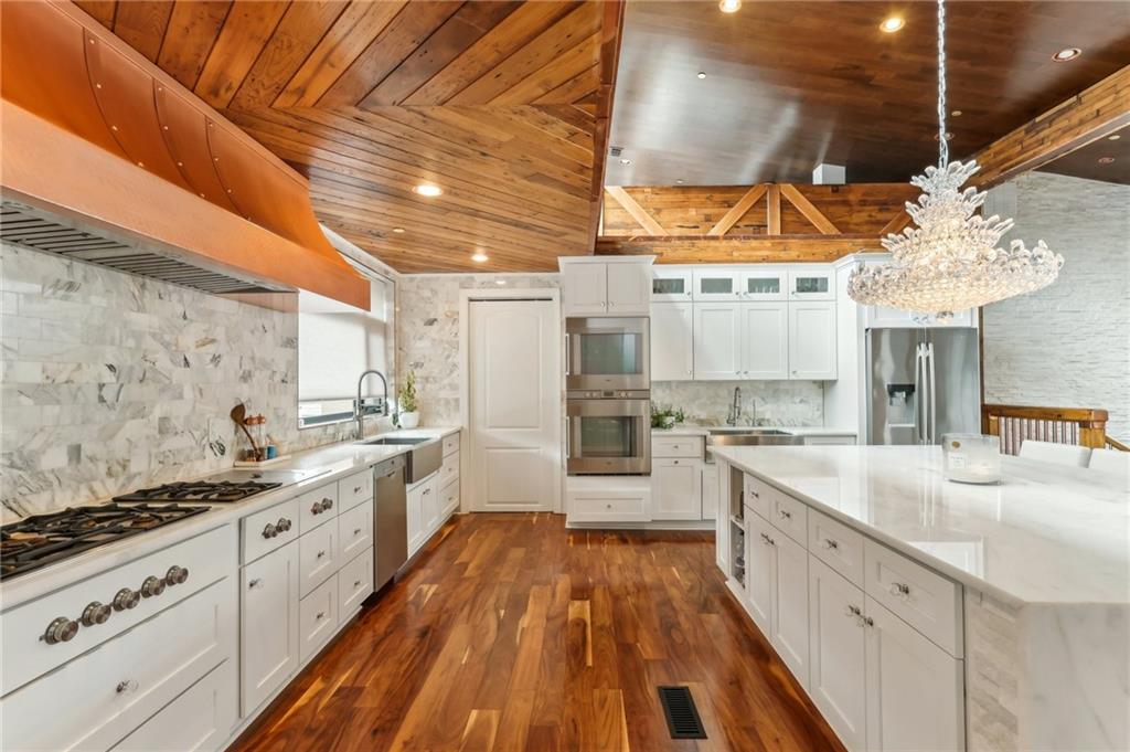 215 25th Street, Unit 7 Pittsburgh, PA 15222 - Photo 15 of 49 a large white kitchen with a stove a sink dishwasher and white cabinets with wooden floor