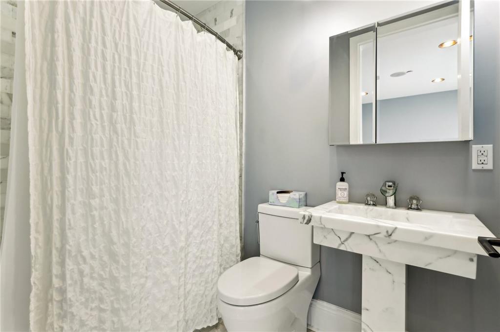 215 25th Street, Unit 7 Pittsburgh, PA 15222 - Photo 31 of 49 a bathroom with a toilet a sink and a mirror