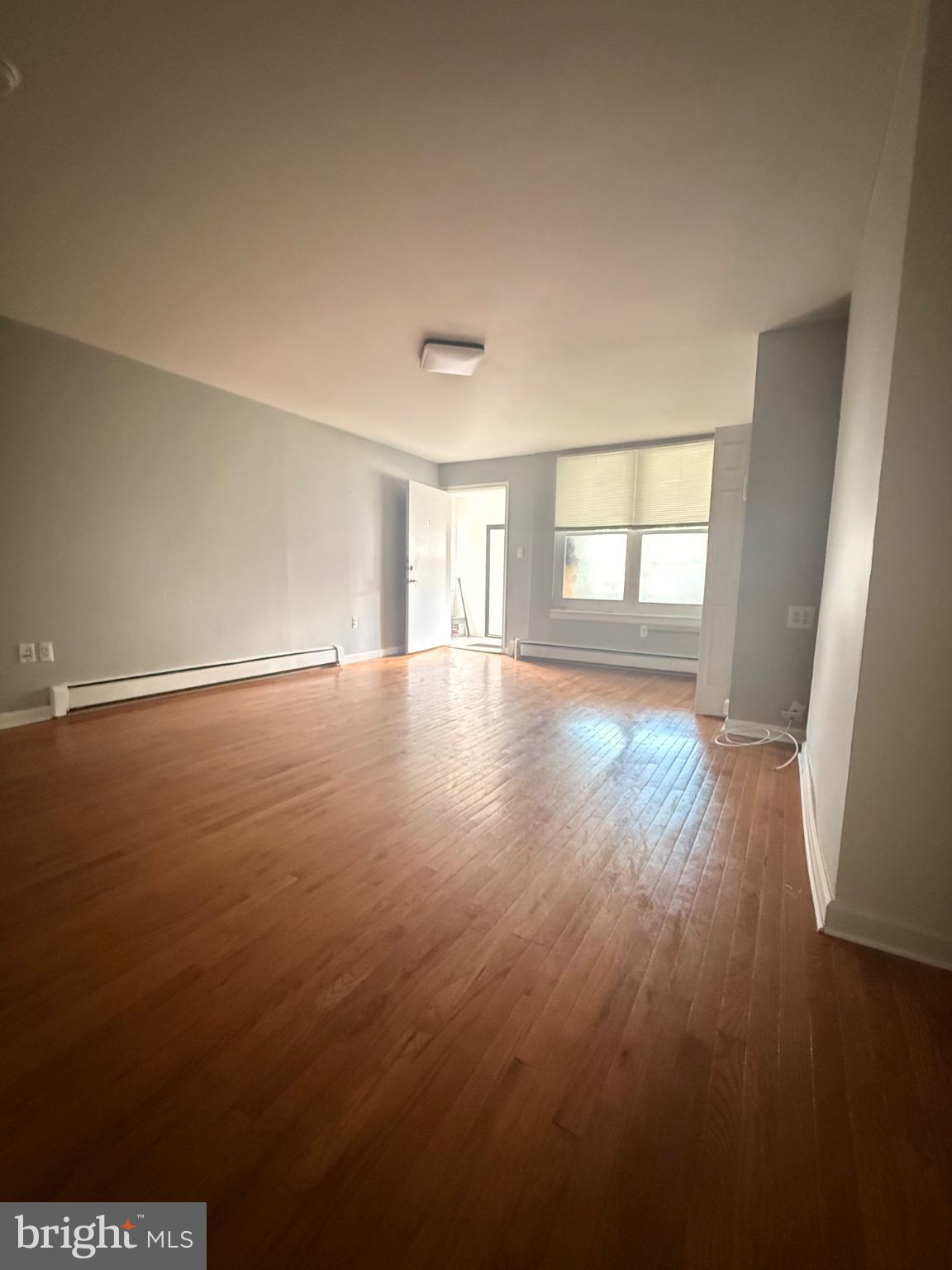 822 Wynnewood Road, Unit 1 Philadelphia, PA 19151 - Photo 5 of 16 an empty room with wooden floor and windows