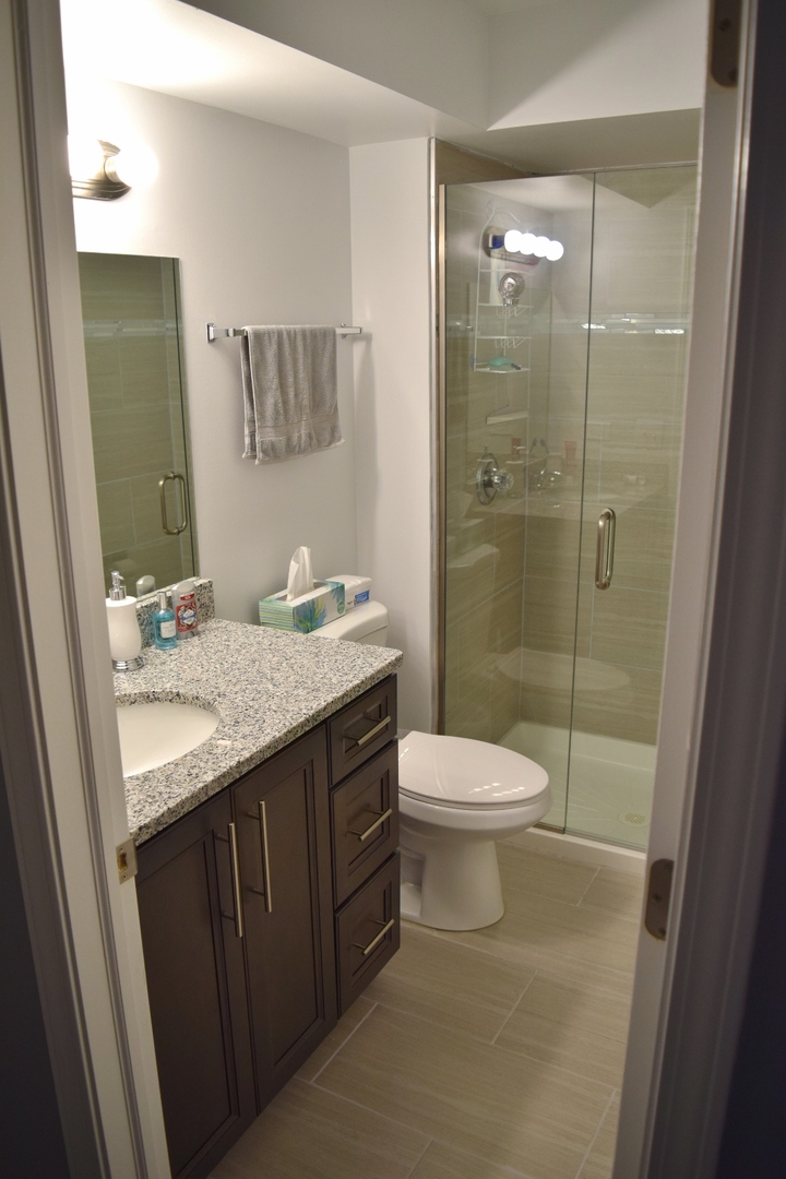 1905 West Golf Road, Unit 1A Mount Prospect, IL 60056 - Photo 12 of 24 a bathroom with a granite countertop sink toilet and shower