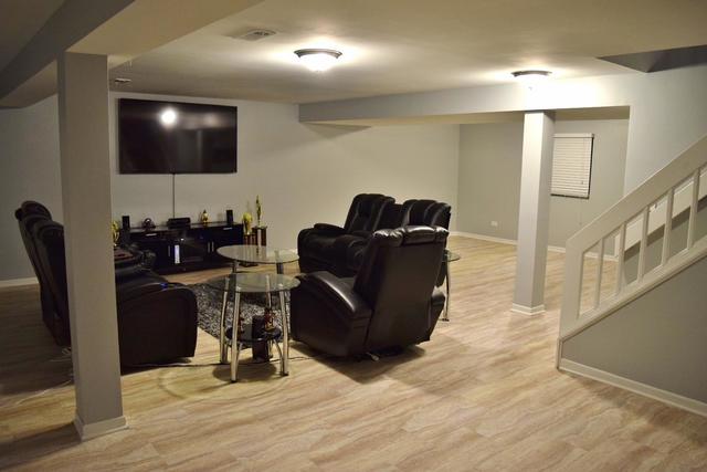 1905 West Golf Road, Unit 1A Mount Prospect, IL 60056 - Photo 23 of 24 a living room with furniture and a flat screen tv