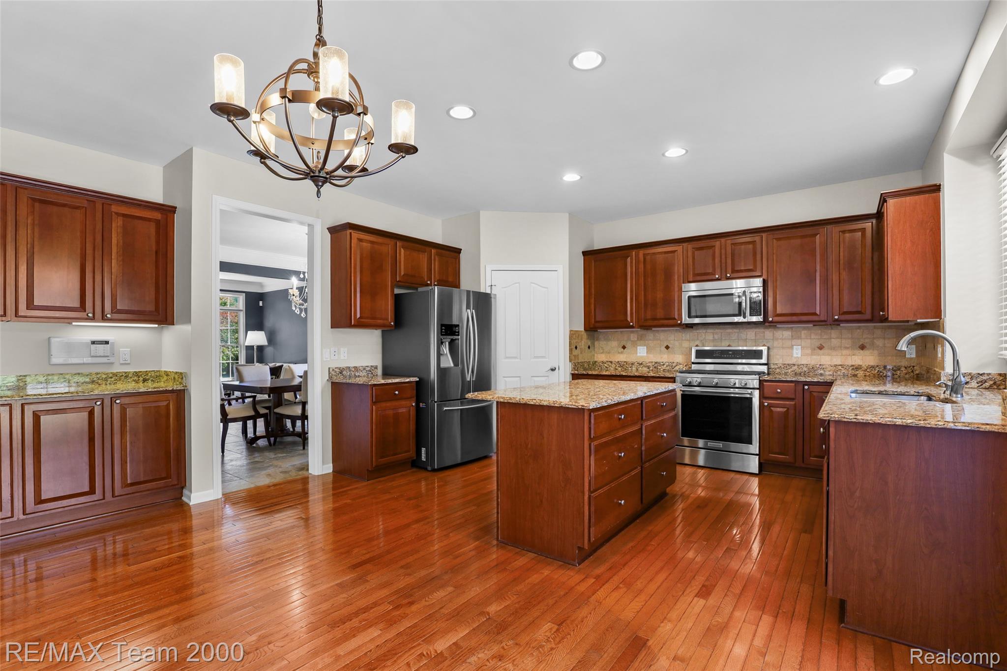 1248 Lasalle Road Canton, MI 48187 - Photo 28 of 67 Spacious kitchen featuring wood-finish flooring, dark wood cabinetry, granite countertops, and stainless steel appliances