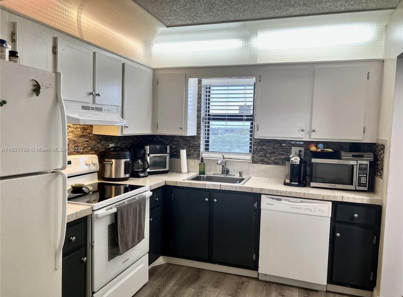 9235 Southwest 8th Street, Unit 507 Boca Raton, FL 33428 - Photo 4 of 16 a kitchen with a sink stove and cabinets