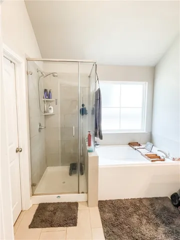 a bathroom with a shower a window and a sink
