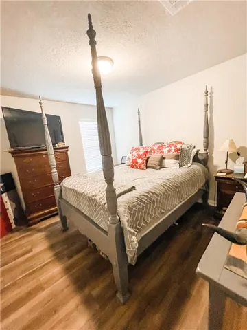 a bedroom with a bed and wooden floor