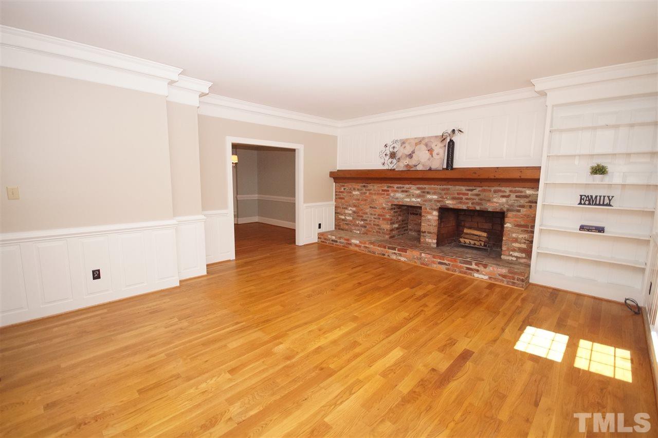 5012 Trail Ridge Drive Raleigh, NC 27613 - Photo 3 of 25 a view of empty room with wooden floor and fireplace