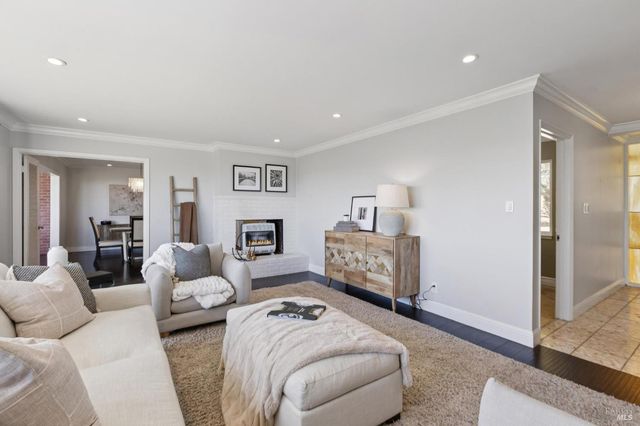 a view of a dining room with furniture a chandelier and wooden floor
