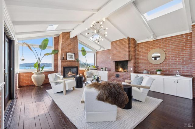 a living room with fireplace furniture and a large window