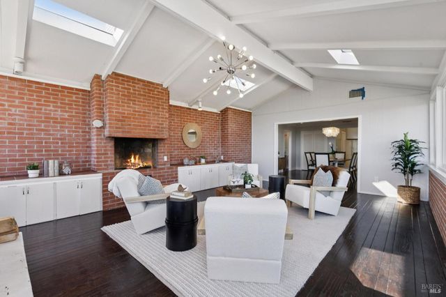 a kitchen with stainless steel appliances granite countertop sink a window and white cabinets