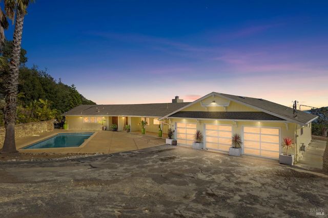 a large kitchen with granite countertop lots of counter space and view of living room