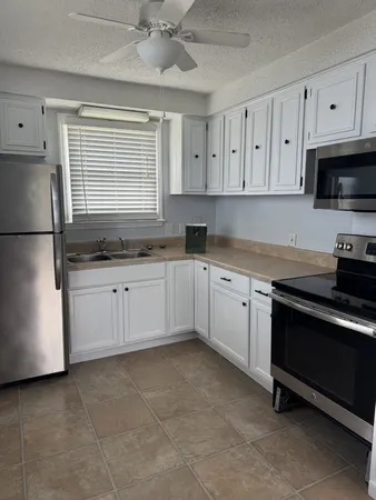 a kitchen with stainless steel appliances granite countertop a sink a stove a refrigerator and cabinets