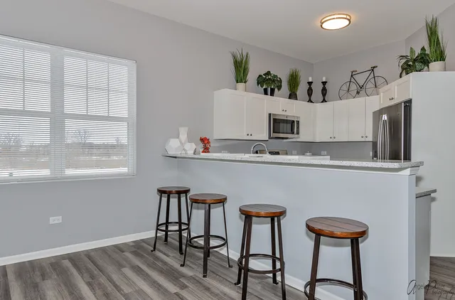 a kitchen with stainless steel appliances granite countertop a stove a sink refrigerator and a microwave