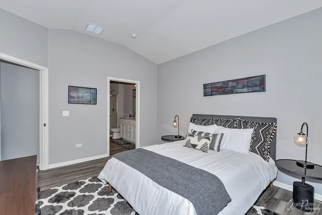 a bedroom with bed and wooden floor