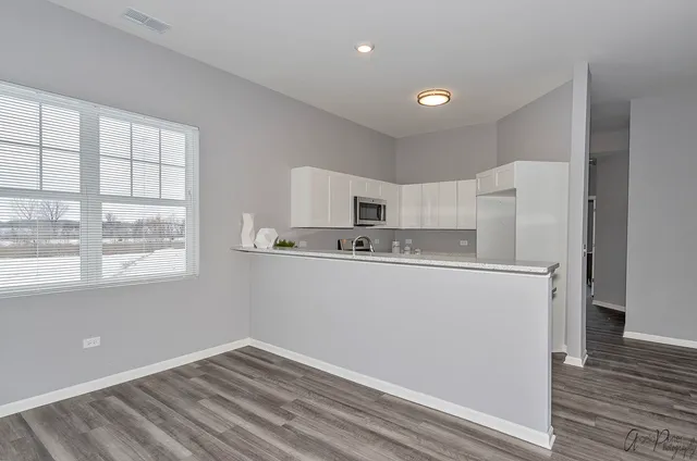 a kitchen with granite countertop a stove a sink and a microwave
