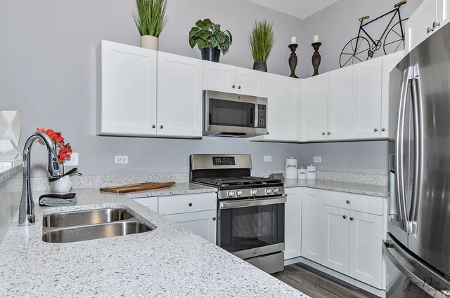 a kitchen with granite countertop a sink stove and refrigerator