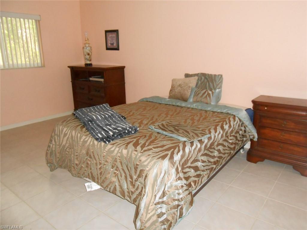 18331 Useppa Road Fort Myers, FL 33967 - Photo 10 of 15 a bedroom with a bed and dresser with lamp