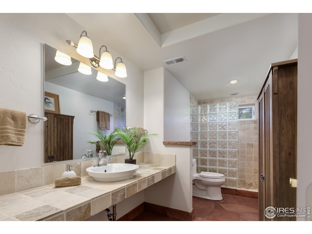 187 Wichita Road Lyons, CO 80540 - Photo 26 of 47 a bathroom with a granite countertop sink a toilet and a mirror