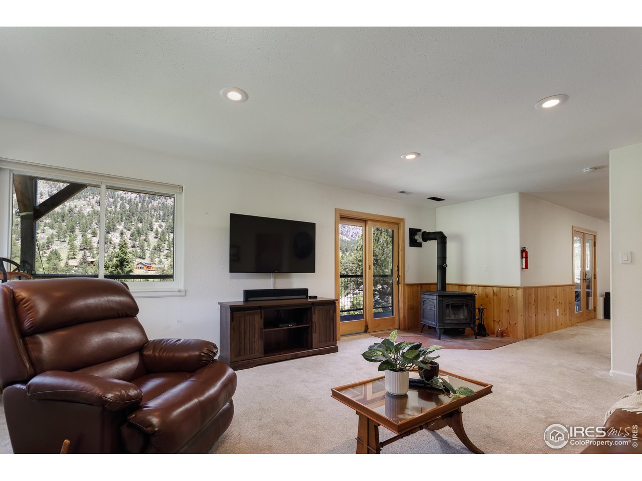 187 Wichita Road Lyons, CO 80540 - Photo 28 of 47 a living room with furniture a flat screen tv and a large window
