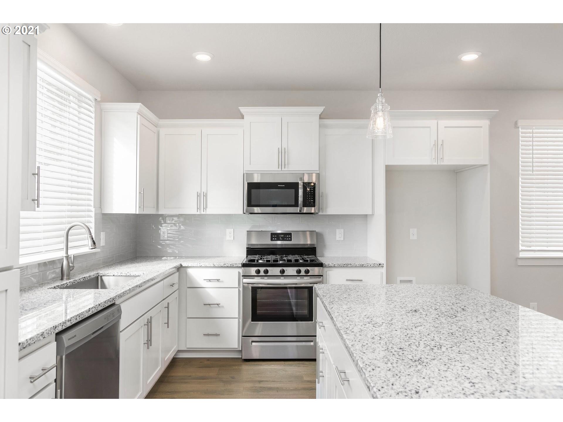 38467 Maple Street, Unit HS 11 Sandy, OR 97055 - Photo 2 of 7 a kitchen with granite countertop a sink stainless steel appliances and cabinets