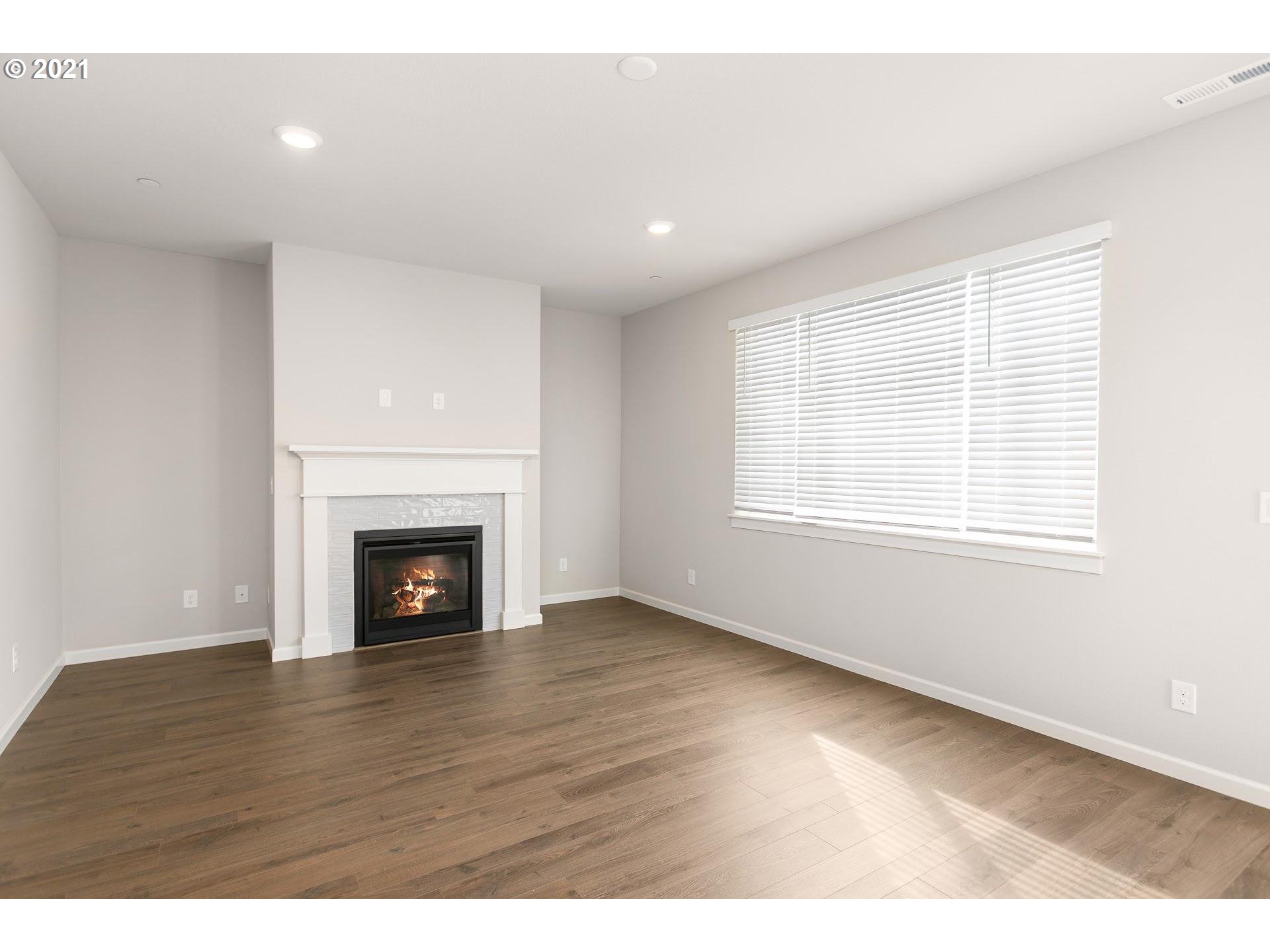 38467 Maple Street, Unit HS 11 Sandy, OR 97055 - Photo 3 of 7 a view of an empty room with wooden floor fireplace and a window