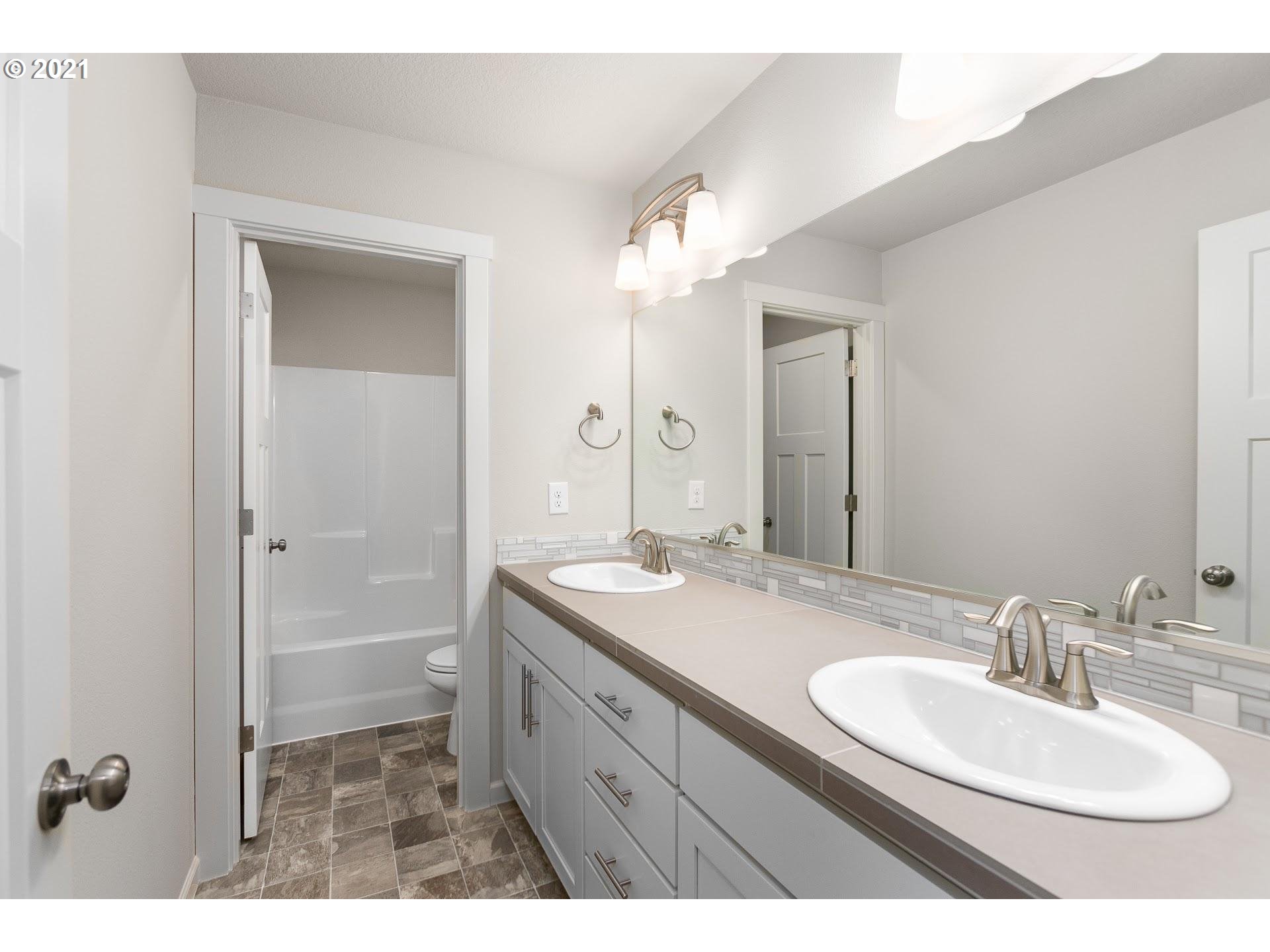 38467 Maple Street, Unit HS 11 Sandy, OR 97055 - Photo 6 of 7 a bathroom with a sink double vanity granite tub and a mirror