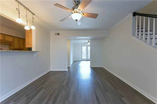 a view of a room with wooden floor and a ceiling fan