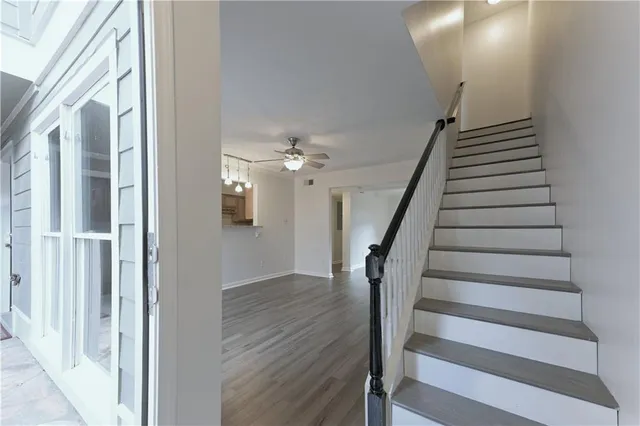 a view of a hallway with wooden floor and staircase