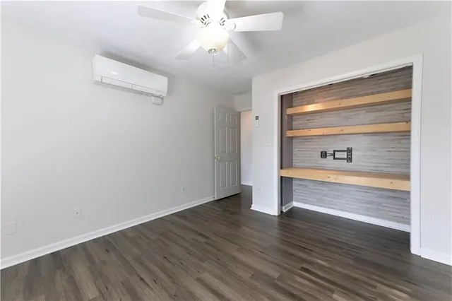 a view of an empty room and window with wooden floor