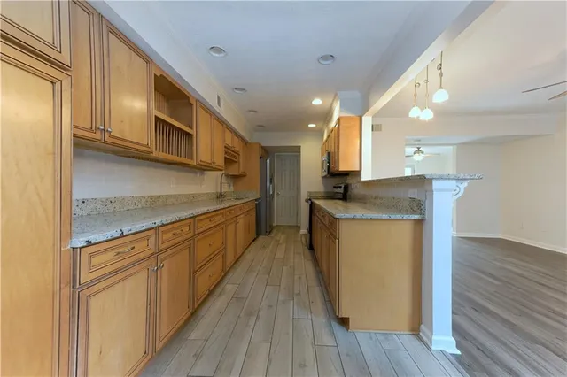 a kitchen with stainless steel appliances granite countertop wooden cabinets a stove top oven and a sink