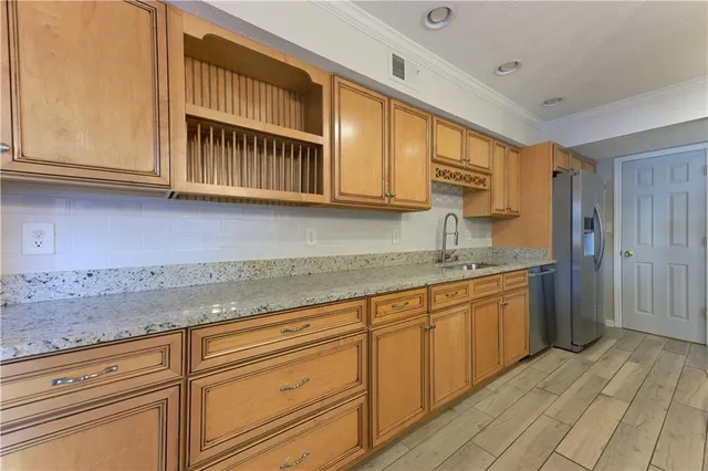 a kitchen with granite countertop a sink cabinets stainless steel appliances and a counter space