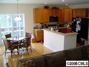 6506 Elfreda Road Charlotte, NC 28270 - Photo 3 of 8 a kitchen with a table chairs and a refrigerator