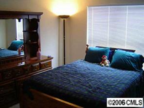 6506 Elfreda Road Charlotte, NC 28270 - Photo 6 of 8 a bedroom with a bed and a lamp