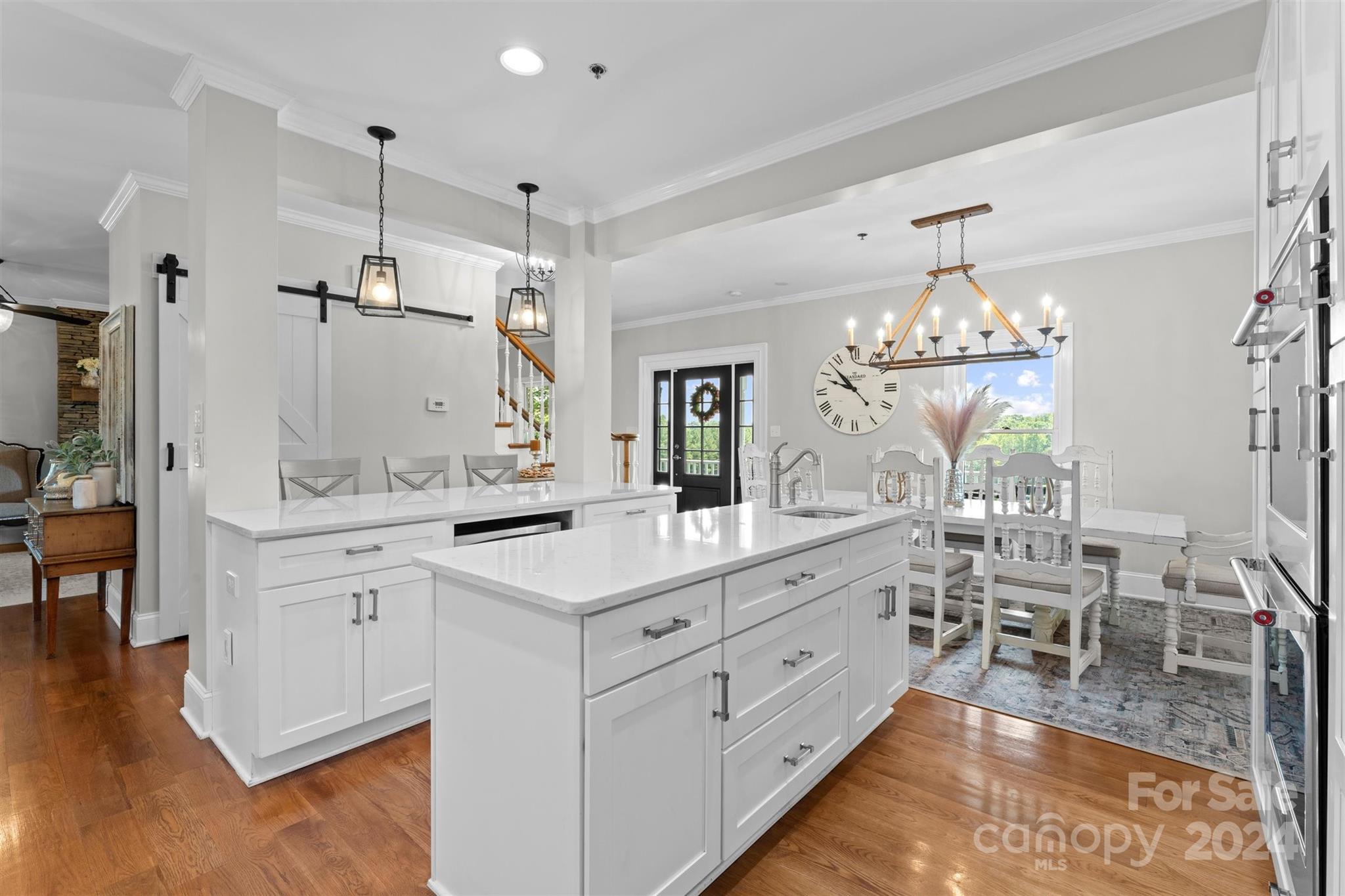 7755 Stokes Ferry Road Salisbury, NC 28146 - Photo 11 of 47 a large white kitchen with a large island oven a stove and a wooden floors