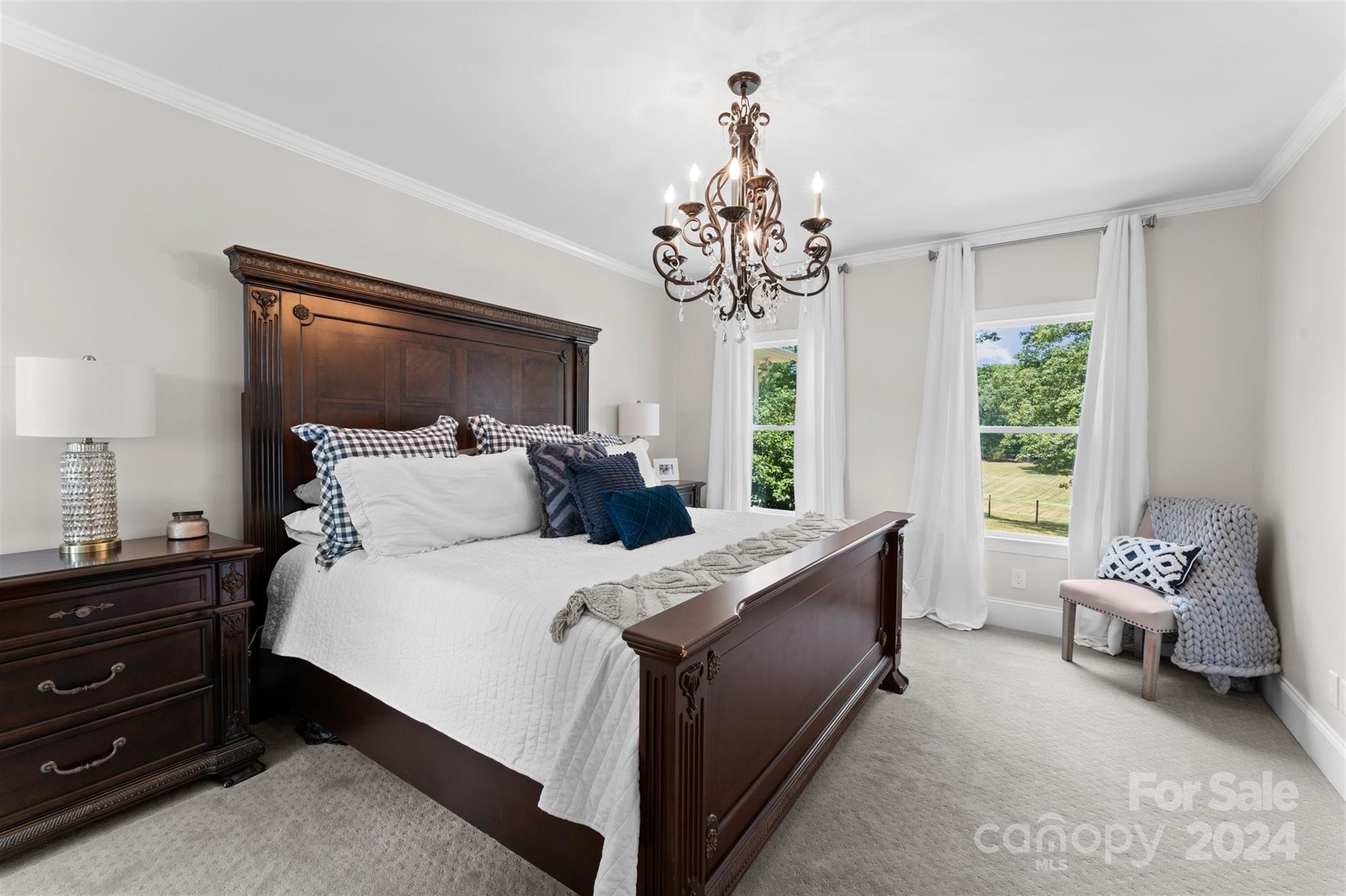 7755 Stokes Ferry Road Salisbury, NC 28146 - Photo 15 of 47 a bedroom with a bed and a chandelier